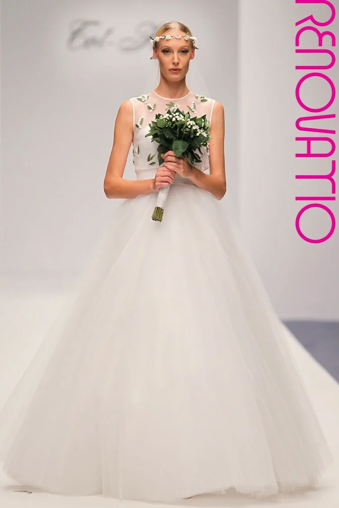 TOT-HOM COLECCIÓN O/I 16.17 Alta Costura Novias  Vestido de novia princesa de falda de volúmenes de gasa y tul blancos y velo bordado con flores blancas y hojas verdes. Cuerpo en forma de chaleco cerrado por la espalda sin mangas y diadema bordados con los mismos motivos. 
