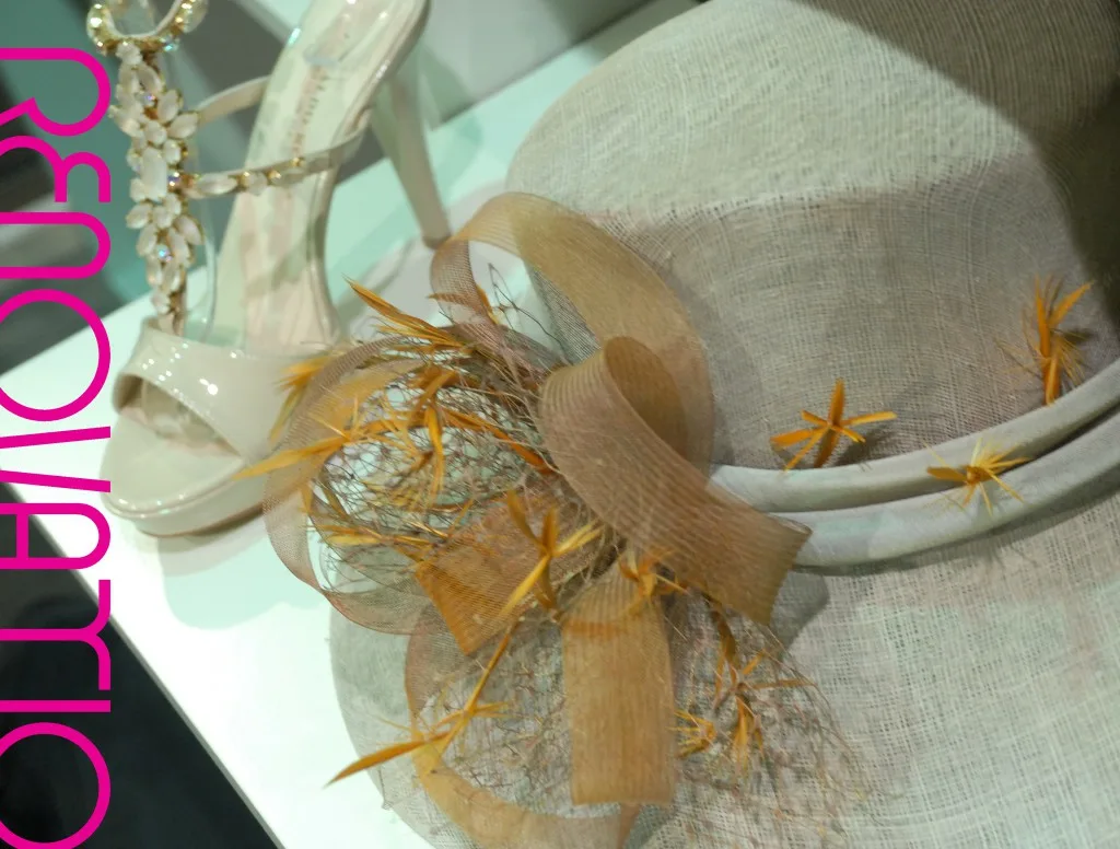 Osvaldo Rossi para Il Tacco te viste con esta sandalia joya en charol beige claro con piedras en forma de flor y Mar Cano se agencia este noble sombrero de base de sinamay con doble volante alrededor de la copa de crin y con adorno de tiras de crin y redecilla francesa.