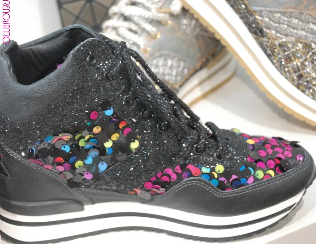 IL TACCO. 2STARGOLD. Revolucionarias zapatillas deportivas de caña alta en piel negra con efecto envejecido y lentejuelas multicolor. La purpurina negra está incrustada. Con apliques de estrellas en el talón. Cordones laminados en negro con puntas en níquel metalizado. Suela de goma bicolor en blanco marfil y negro con caucho alrededor del talón. Plantilla ergonómica cubierta por una cuña de 4.5cm de piel de becerro.
